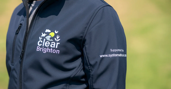 Close-up of a navy softshell jacket featuring detailed embroidered branding for 