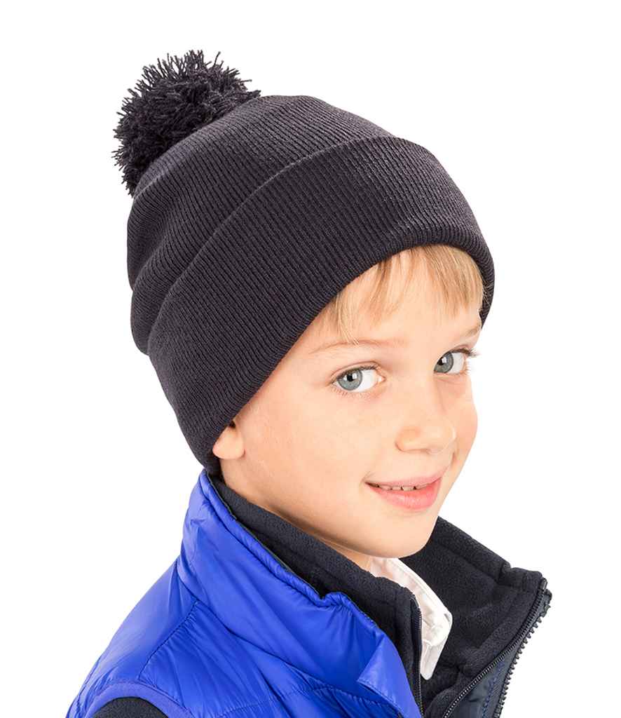 Result Core Kids Pom Pom Beanie in ONE Black by Result Winter Essentials — Custom branded clothing by Print Press, featuring premium embroidery produced in our specialist print lab in the UK.