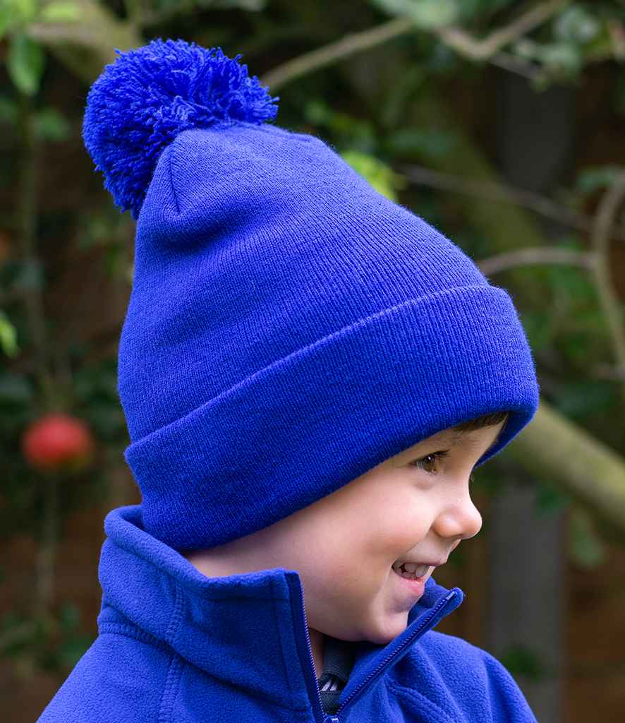 Result Core Kids Pom Pom Beanie in ONE Royal Blue by Result Winter Essentials — Custom branded clothing by Print Press, featuring premium embroidery produced in our specialist print lab in the UK.