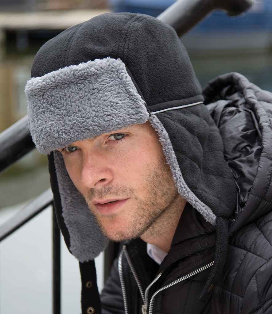Result Ocean Trapper Hat in Black Grey by Result Winter Essentials — Custom branded clothing by Print Press, featuring premium embroidery produced in our specialist print lab in the UK.