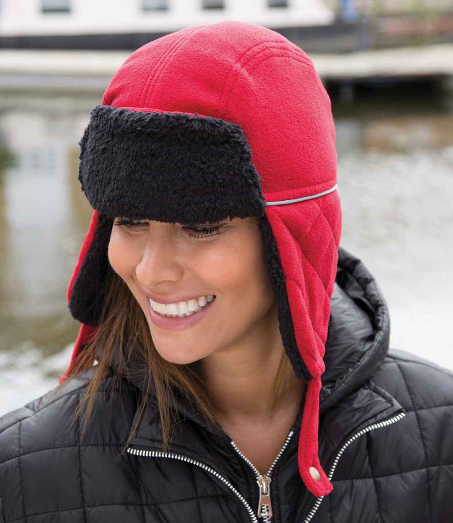 Result Ocean Trapper Hat in Red Black by Result Winter Essentials — Custom branded clothing by Print Press, featuring premium embroidery produced in our specialist print lab in the UK.