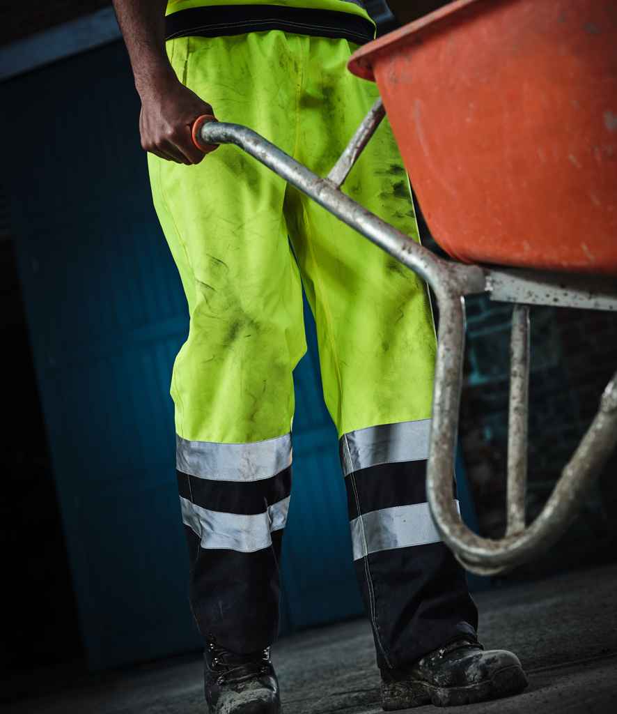 Regatta High Visibility Pro Contrast Overtrousers in Yellow Navy by Regatta High Visibility — Custom branded clothing by Print Press, featuring premium embroidery produced in our specialist print lab in the UK.