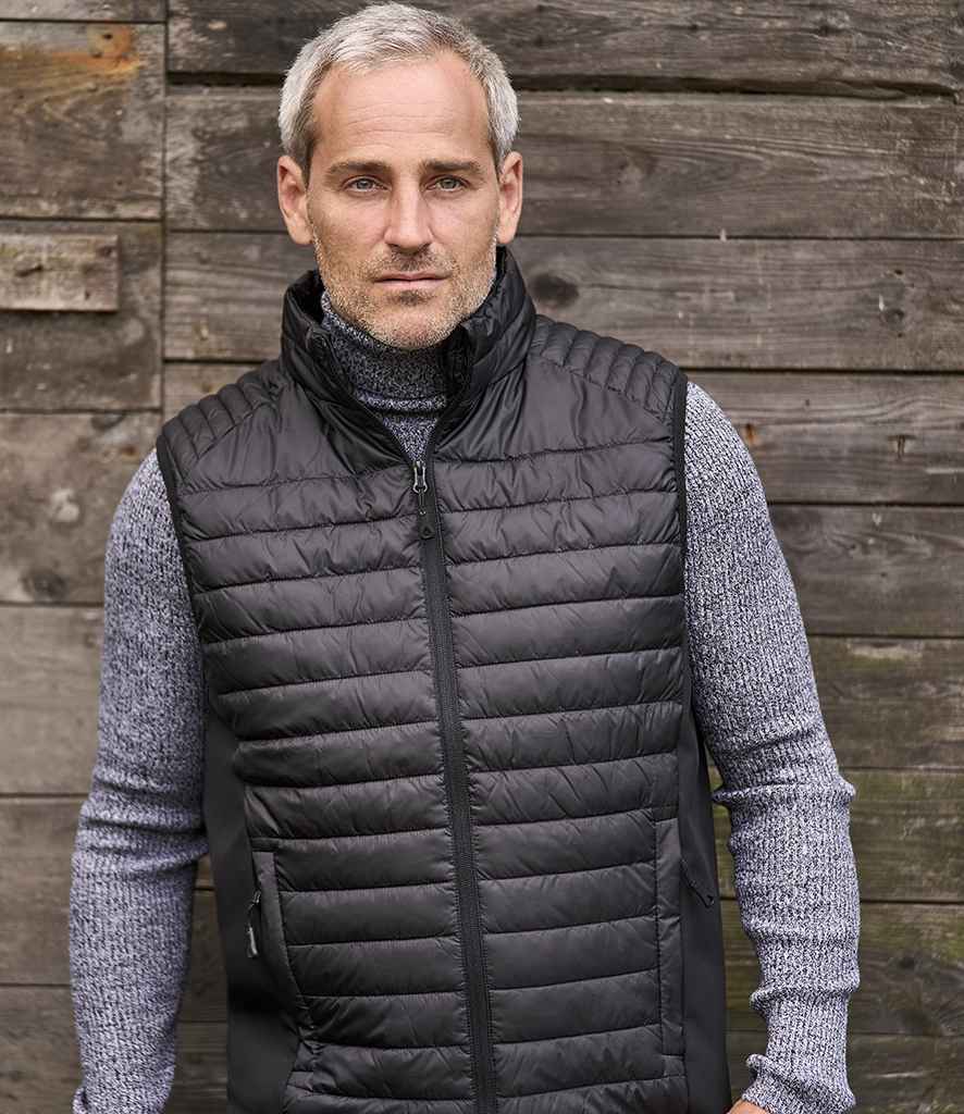 Tee Jays Crossover Padded Bodywarmer in Black Black by Tee Jays — Custom branded clothing by Print Press, featuring premium embroidery produced in our specialist print lab in the UK.